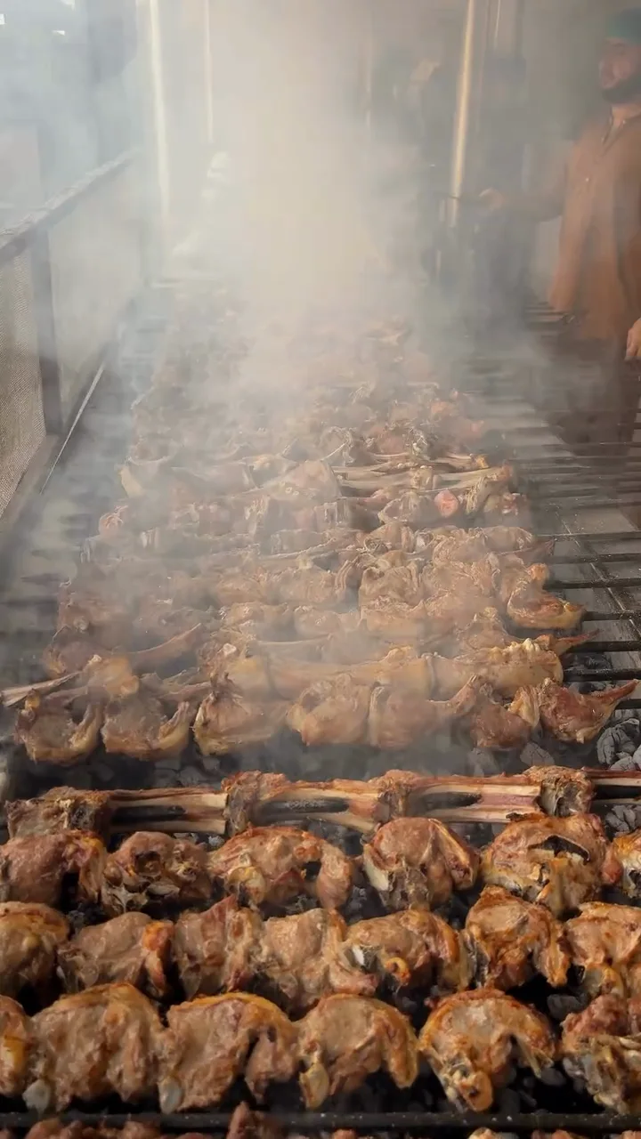 Meat cooking over a charcoal grill at Ghani Shinwari