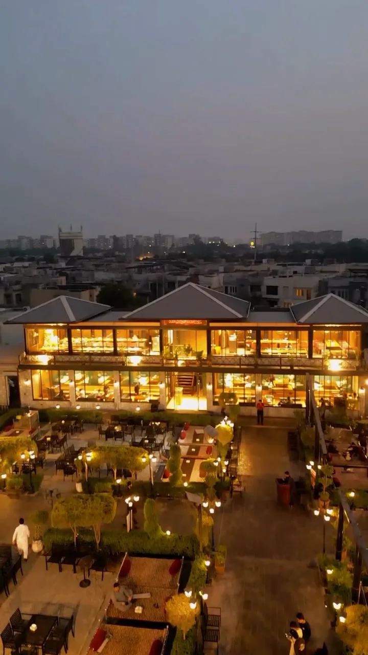Ghani Shinwari’s illuminated restaurant and outdoor tables at dusk